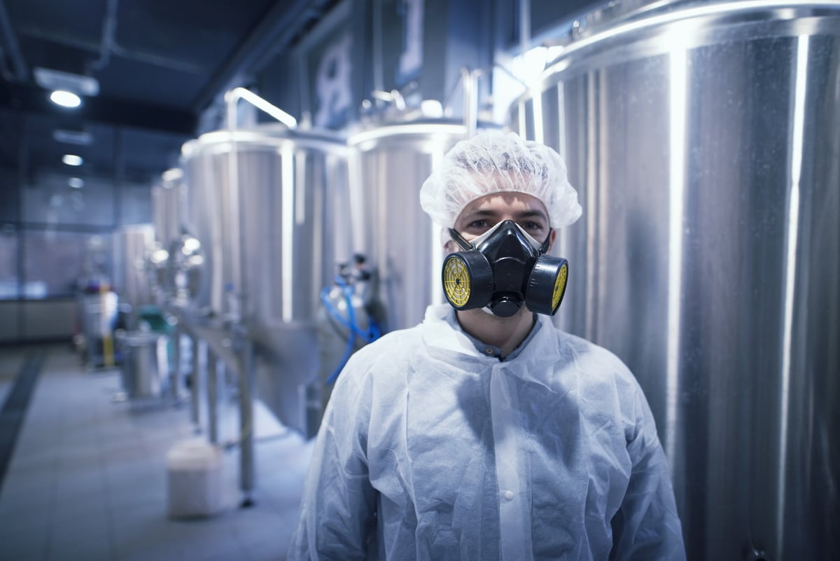Un technologue ouvrier industriel portant une combinaison de matières dangereuses dans une usine de production